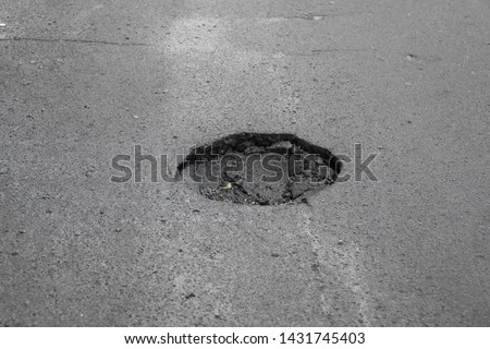 Damaged asphalt pavement road with dangerous potholes.