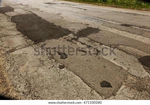Damaged
asphalt road with potholes. Bad road. Pitch Repair. Repair of
asphalt repair. Bad asphalt, dangerous road, Broken automobile
road, cracks, holes, potholes in the
asphalt