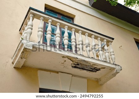 Damaged balcony with cracked concrete and falling plaster, floor need for repair. Damaged balcony with cracks in reinforced concrete structure, risks for residents. deteriorating concrete balcony