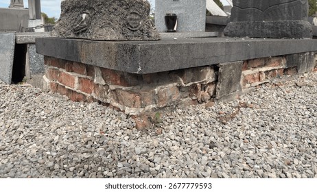 Damaged brick base of an old grave in a cemetery