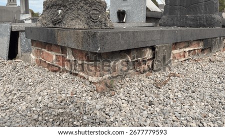 Damaged brick base of an old grave in a cemetery