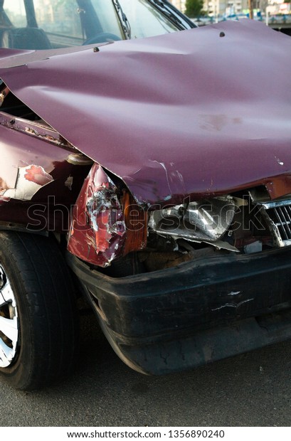 Damaged car after the accident. Wrinkled metal\
hood. Broken engine.