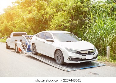 Damaged Car Truck Slides And The White Car In The Accident On Local Road With Sun Flare And Green Plants Background.