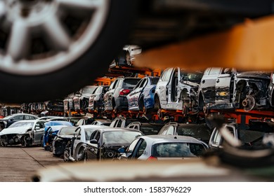 Damaged cars waiting in a scrapyard to be recycled or used for spare part - Shutterstock ID 1583796229