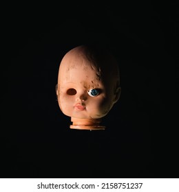 Damaged Dirty Doll head on black background