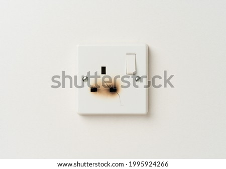Damaged electrical domestic power socket with cracks and burn marks