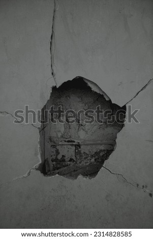 Damaged grungy crack and broken concrete wall on white, concept of escape, freedom. A hole cut in a grey concrete wall for installing the wiring. Old gray wall. damaged background
