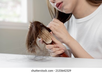 Damaged Hair, Frustrated Asian Young Woman, Girl Hand In Holding Brush Splitting Ends Messy While Combing Hair, Unbrushed Dry Long Hair. Health Care Beauty, Portrait Isolated On White Background.