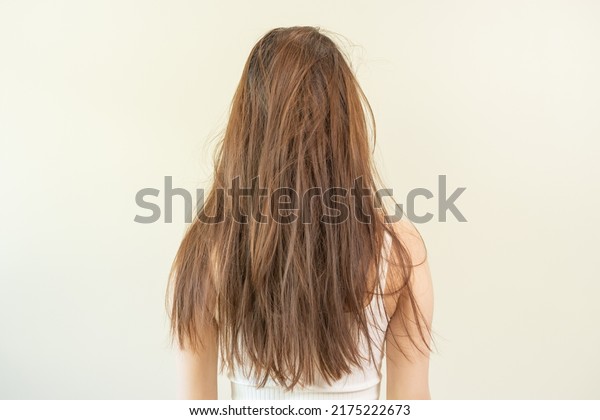 Damaged hair, frustrated asian young woman, girl in\
splitting ends, messy unbrushed dry hair and frizzy with long\
disheveled hair, health care of beauty. Portrait isolated on\
background, Back view.