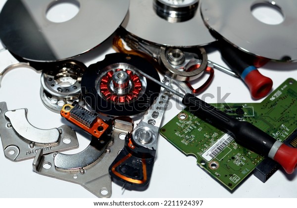 Damaged Hard disk drive components with disks, read\
write head, spindle motor, suspension, pivot, voice coil motor VCM,\
E-block, data track, platters, head arm, actuator and main logic\
board chip
