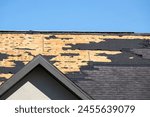 Damaged house roof with missing shingles after hurricane Ian in Florida. Consequences of natural disaster