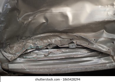 Damaged Metal. Shooting A Dent On A Car After An Accident. Close-up Shot Of Distorted Steel. Car Side Door After Impact. The Texture Of The Distorted Car Body.