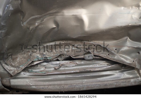Damaged metal. Shooting a dent on a\
car after an accident. Close-up shot of distorted steel. Car side\
door after impact. The texture of the distorted car\
body.