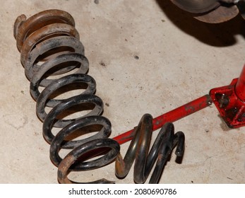 Damaged Old Car Rusty Coil Spring Parts On Concrete Floor