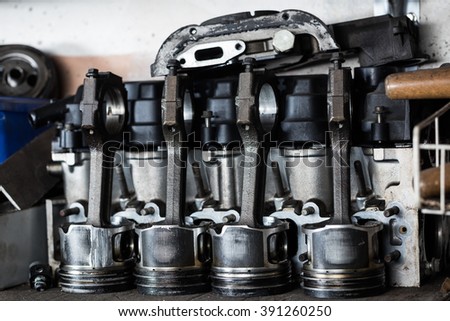 Damaged old engine machine piston with intake valve at repair service. Garage concept