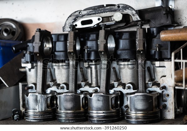 Damaged old engine machine piston with
intake valve at repair service. Garage
concept