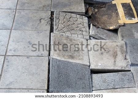 Damaged pavement surfaces can be dangerous for pedestrians to stumble and fall.