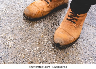 damaged persons shoes on salted pavement in the city during winter season
