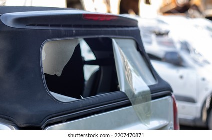 Damaged Roof Material On The Back Of The Convertible. Vandalism, Thieves Cut The Roof Of A Convertible From Behind. Theft Of Things From The Car. Criminal Incident. Car Burglary