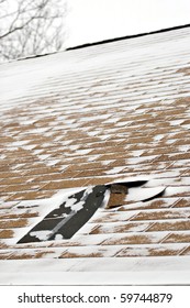 Damaged Roof Shingles Blown Off A Home From A Windy Winter Storm With Strong Winds.