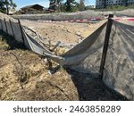 A damaged silt fence at a construction site. A Silt fence is a perimeter control device use to temporarily manage sediment at construction sites.