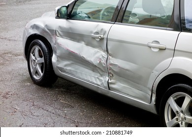 Damaged silver car, scratches on the doors