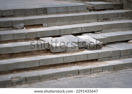 Damaged stair steps made from paving slab unsafe for pedestrians. Broken staircase. Broken stair with steps from gray paving slabs. Poor quality of brickwork. Renovation and repair work concept
