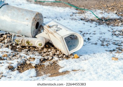 Damaged surveillance camera on the ground as a concept of failing policy of total surveillance. Vandalism act during riots. Protect your identity and personal information from surveillance and CCTV