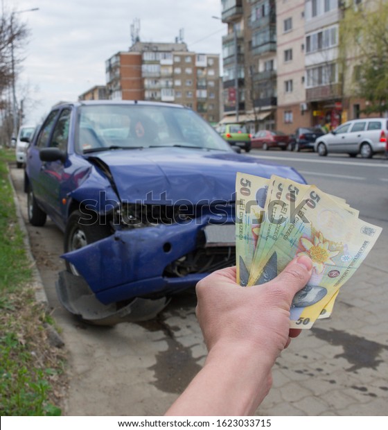 Damaged vehicle after car accident parked on the\
roadside. Car insurance concept with Romanian money (lei) – the\
cost of car insurance or the lack of car insurance is expensive.\
Selective focus.