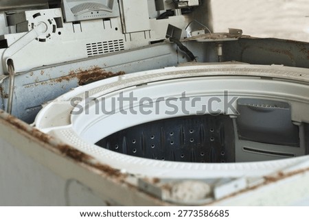 damaged washing machine with rust and exposed internal parts, representing appliance failure, maintenance issues, repair service, and household problems.