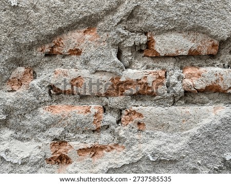 A Damaged and Weathered Wall, Where The Outer Layer of Plaster or Concrete Has Cracked and Fallen Away, Revealing The Bricks Beneath