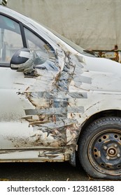 Damaged Whire Small Car With Duct Tape Repair