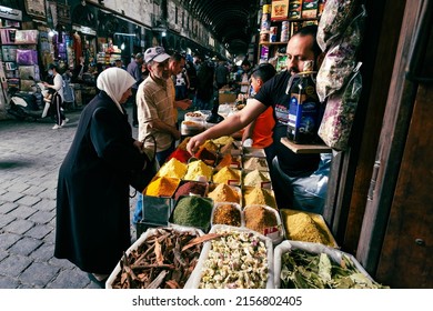 Damascus, Syria -May, 2022: Older Couple Buying Food, Herbals And Spices At Suq Al Hamidiyah Street Market In Damascus