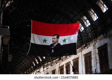 Damascus, Syria -May, 2022: Portrait image of Bashar al-Assad, President of Syria on syrian flag in Suq
