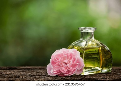 Damask rose flower and oil on nature background.
