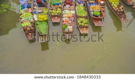Damnoen Saduak Floating Market or Amphawa. Local people sell fruits, traditional food on boats in canal, Ratchaburi District, Thailand. Famous Asian tourist attraction.