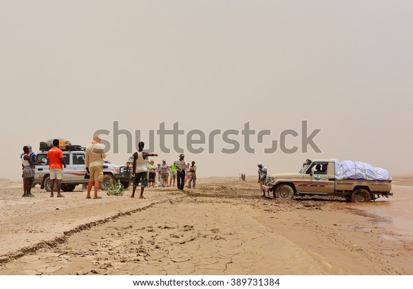 DANAKIL, ETHIOPIA-MARCH 26: Caravan of Land\
Cruiser 4wd cars crosses a stream in the desert flooded by a strong\
storm fallen in the surrounding mountains 2 days before on March\
27, 2013. Afar region.