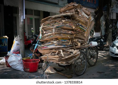 Danang / Vietnam - April 22 2019: A Homeless Man Is Breaking Down Cardboard Boxes To Recycle For Money.