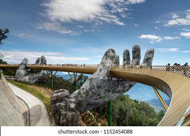 Danang, Vietnam - July 5, 2018: The Golden Bridge is lifted by two giant hands in the tourist resort on Ba Na Hill in Danang, Vietnam. Ba Na Hill mountain resort is a favorite destination for tourists