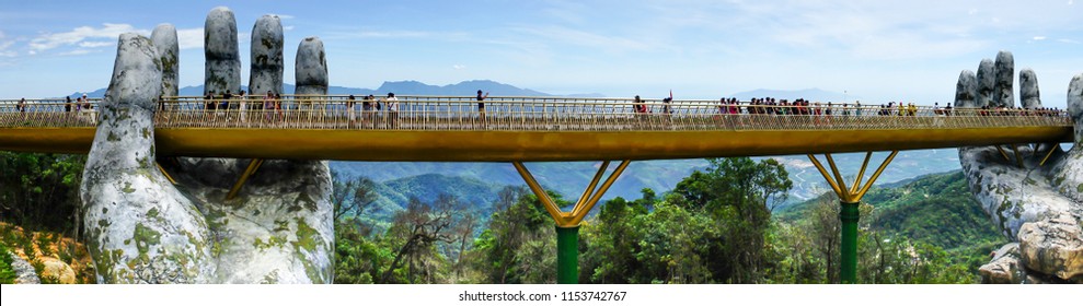 Danang, Vietnam - July 5, 2018: The panoramic view of Golden Bridge is lifted by two giant hands in the tourist resort on Ba Na Hill in Danang, Vietnam. Ba Na Hill mountain resort is a favorite destin