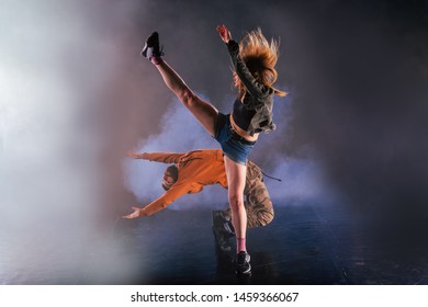 Dance couple shows off their moves the girl is throwing her leg high in the sky while the man is leaning back towards the ground. - Powered by Shutterstock