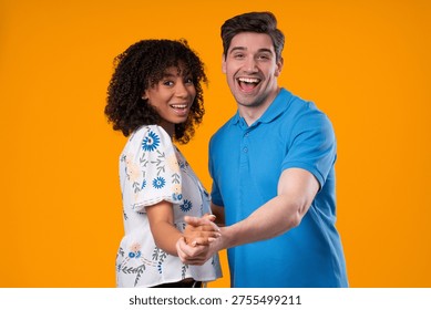 Dance Courses, Class. Romantic date - loving couple in love dancing closely together, smiling, holding hands on yellow studio background. Happy partners. High quality