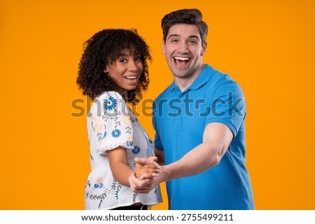 Dance Courses, Class. Romantic date - loving couple in love dancing closely together, smiling, holding hands on yellow studio background. Happy partners. High quality