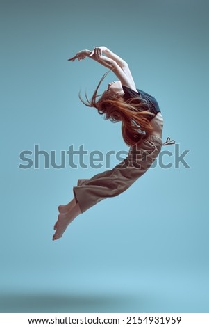 Dance expression. Modern ballet dancer girl flies in jump. Contemporary ballet. Full-length studio portrait.
