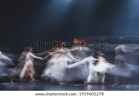 dance of a group of people on stage at long exposure.