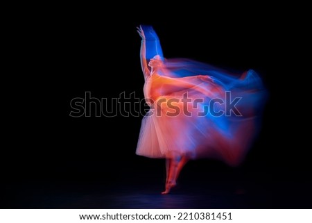 Dance of light and glow. Beautiful grace girl, female ballet dancer dancing isolated over black background in mixed neon light. Art, motion, action, flexibility, creativity and ad concept.