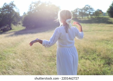 Dance In Nature.
Beautiful Young Lady Standing In A Field In A Long Dress.