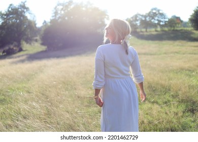 Dance In Nature.
Beautiful Young Lady Standing In A Field In A Long Dress.