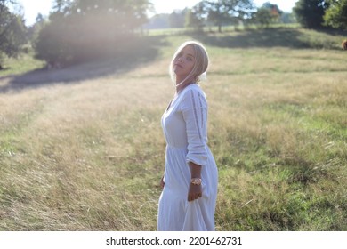 Dance In Nature.
Beautiful Young Lady Standing In A Field In A Long Dress.