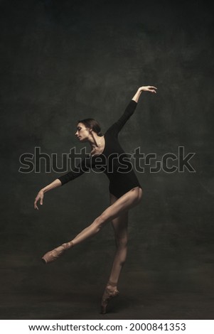 Dance on the tips of toes. Solo. Young and graceful ballet dancer isolated on dark background. Art, motion, action, flexibility, inspiration concept.